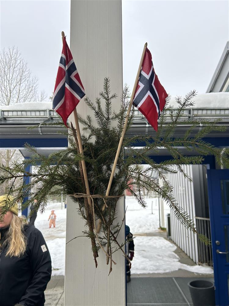 Bilde fra arrangementet "OL i Oddeskogen barnehage". Pynt på stolpe utenfor barnehagen, flagg og granbar. - Klikk for stort bilde